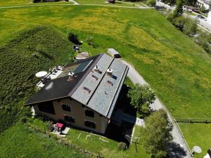 einen Blick über ein Haus mit Solardach in der Unterkunft Chesa Viletta in La Punt-Chamues-ch