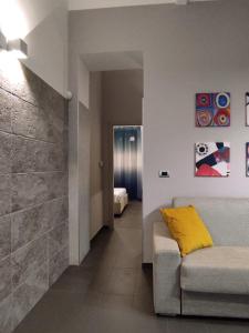 a living room with a yellow pillow on a couch at Le Muse in Licata