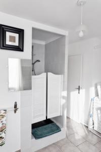 a white bathroom with a sink and a mirror at La Barcelle, une pause nature. in Perrigny