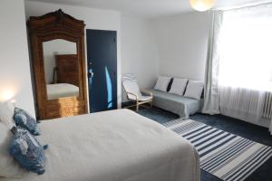 a bedroom with a bed and a couch and a mirror at La Barcelle, une pause nature. in Perrigny