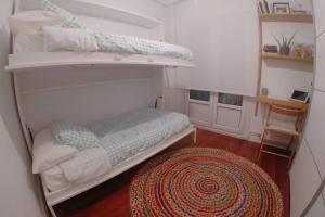 - une chambre avec des lits superposés et un tapis dans l'établissement Apartamento en el centro de Mundaka EBI646, à Mundaka