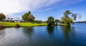 VR Rotorua Lake Resort في روتوروا: منزل على شاطئ البحيرة