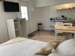 Appart’hôtel saint patrice في بايو: غرفة نوم بسرير وطاولة ومطبخ