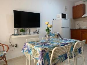 uma sala de jantar com uma mesa com cadeiras e uma televisão em Apartamento PUERTO em Mazagón