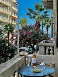 een tafel met een fles wijn en glazen op een balkon bij Amiral Courbet Apartment in Juan-les-Pins