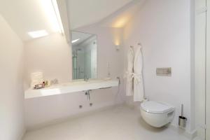 a white bathroom with a sink and a toilet at EMAJ Boutique Hotel in Guimarães