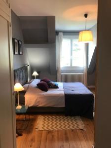 a bedroom with a bed and a window and two lamps at Les chambres de Marie in Tours