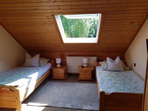 a attic room with two beds and a window at Gästezimmer Aschenbrenner in Bad Rodach