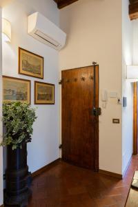 a hallway with a wooden door and a potted plant at Fiesole's cozy Apartment 1 in Fiesole
