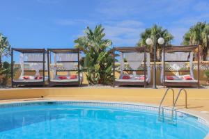 a pool at a resort with chairs and a table at Quinta Nova Vale Del Rey in Carvoeiro