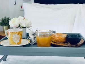 - un plateau avec deux tasses de jus d'orange et une assiette de nourriture dans l'établissement Mica Apartments, à Sere Kunda
