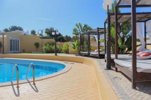 a pool with a gazebo next to a house at Quinta Nova Vale Del Rey in Carvoeiro