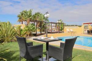a table and chairs next to a swimming pool at Quinta Nova Vale Del Rey in Carvoeiro