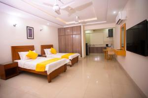 1 dormitorio con 2 camas y TV de pantalla plana en Maati Spaces - Studio Apartments, en Lahore