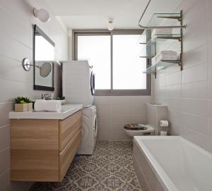 uma casa de banho com um lavatório, uma banheira e um WC. em Superior and Spacious Duplex in the Kerem em Tel Aviv