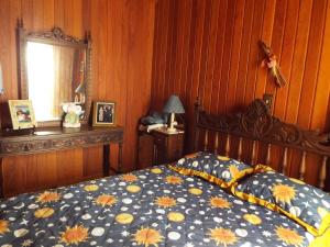 ein Schlafzimmer mit einem Bett mit einer blauen und gelben Bettdecke in der Unterkunft Florada na Serra in Monte Verde