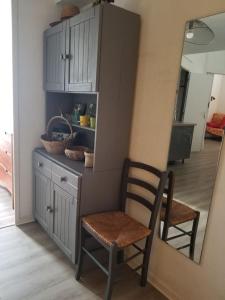 a kitchen with a chair and a counter and a cabinet at Appartement dans la verdure près des plages in Saint-Cyprien-Plage