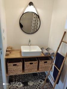 a bathroom with a sink and a mirror at Le studio 22 in Bréhand