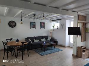 a living room with a couch and a table at Le studio 22 in Bréhand