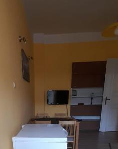 een kamer met een muur met een tv en een tafel bij Apartament Kasztanowy in Gliwice