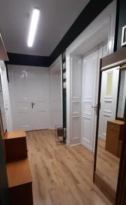 een kamer met twee witte deuren en een houten vloer bij Apartament Kasztanowy in Gliwice