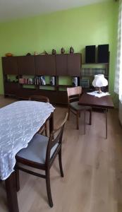 a living room with a table and chairs and a book shelf at Apartament Kasztanowy in Gliwice