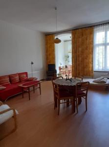 een woonkamer met een tafel en stoelen en een bank bij Apartament Kasztanowy in Gliwice