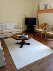 uma sala de estar com uma mesa de centro e um tapete branco em La Poste Saulgond em Saulgond