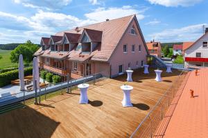 ein großes Haus mit weißen Säulen auf einer Holzterrasse in der Unterkunft ACANTUS Hotel in Weisendorf