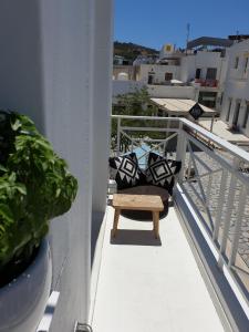 a chair sitting on a balcony with pillows on it at Aretousa Deluxe Downtown Apartment in Skala