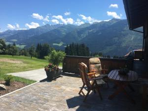 a patio with a table and chairs and mountains at Haus Baumoos in Uttendorf