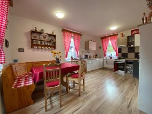 a kitchen and dining room with a table and chairs at Chalupa U kočky in Kovářská