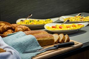 einen Tisch mit Speisen zum Frühstück und Brot in der Unterkunft Kb Hotel in Nersingen