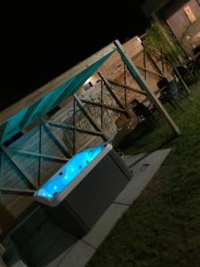 a bathtub with blue lights in a pool at night at Glass Cube in Outes