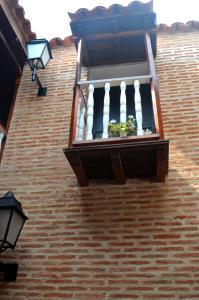 a brick building with a window and a balcony at Hotel Galeria la Trinidad in Cartagena de Indias
