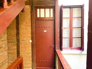 una puerta roja en un edificio de ladrillo con una ventana en Studio des Carmes, en Toulouse