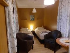 ein Hotelzimmer mit 2 Betten und einem Stuhl in der Unterkunft Rauðuskriður farm in Hólmabæir