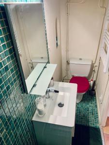 a bathroom with a white sink and a red toilet at Studio des Carmes in Toulouse