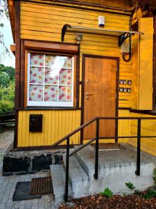 ein gelbes Haus mit einer Tür und einem Fenster in der Unterkunft RailWay Bed HOSTEL in Kaunas