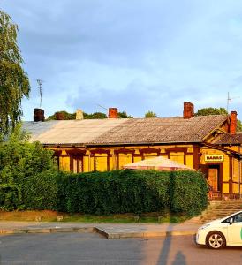 a house with a car parked in front of it at RailWay Bed HOSTEL in Kaunas