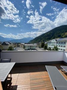 d'un balcon avec bancs et vue sur la ville. dans l'établissement Post Residence Apartments incl ZAK SUMMER CARD by All in One Apartments, à Zell am See