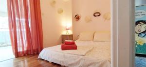 a bedroom with a bed with a red pillow on it at Experience the sweetest nest at Marina Zea in Piraeus
