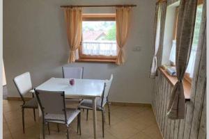 a dining room with a table and chairs and a window at Odpočinková chata na prahu Šumavy in Mochtín