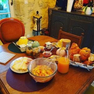 una mesa con alimentos para el desayuno y zumo de naranja en ella en La Vicoise Accueillante en Vic-Fezensac