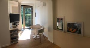 a living room with a table and a television at Het Nekkerhof B&Bio in Mechelen