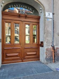 una porta di legno per un edificio con un cartello sopra. di Avalon apart 2 a Legnica