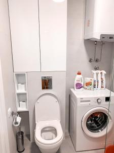 une petite salle de bains avec toilettes et lave-linge. dans l'établissement Bar Exclusiv Soho city Residence, à Bar 34 autres photos
