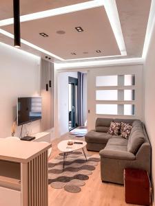 un salon avec un canapé et une télévision dans l'établissement Bar Exclusiv Soho city Residence, à Bar