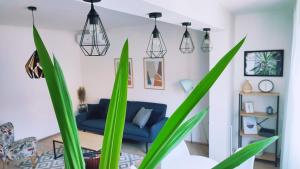 ein Wohnzimmer mit grünen Pflanzen und einem blauen Sofa in der Unterkunft Apartman Lena in Tuzla