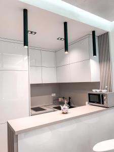 a kitchen with white cabinets and a counter top at Bar Exclusiv Soho city Residence in Bar